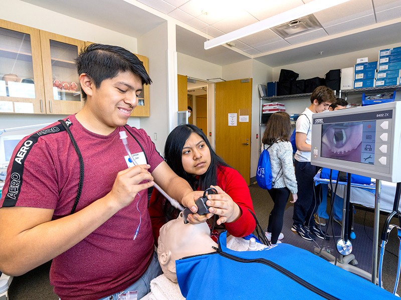 Morton High School students Emilio Jose, left, and Edna Perez-Ambrocio practice their intubation skills on a compliant manikin.